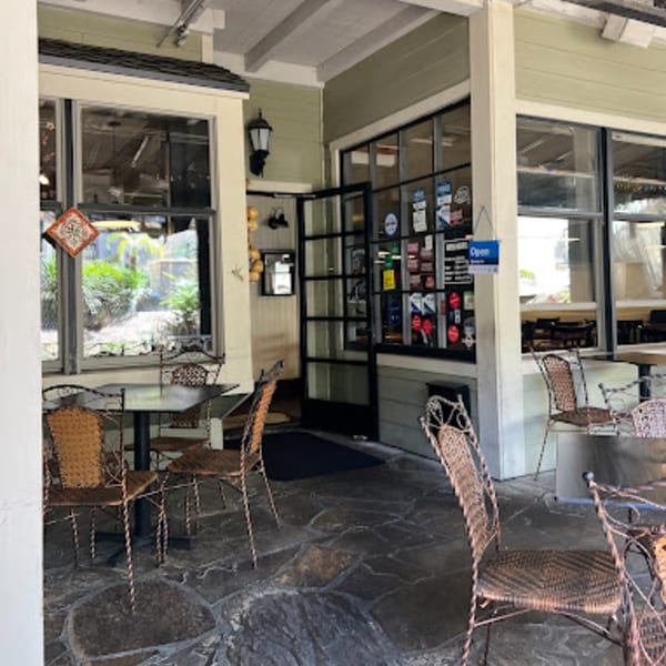 Outdoor patio seating with wrought iron tables and chairs outside Misto Caffe & Bakery.