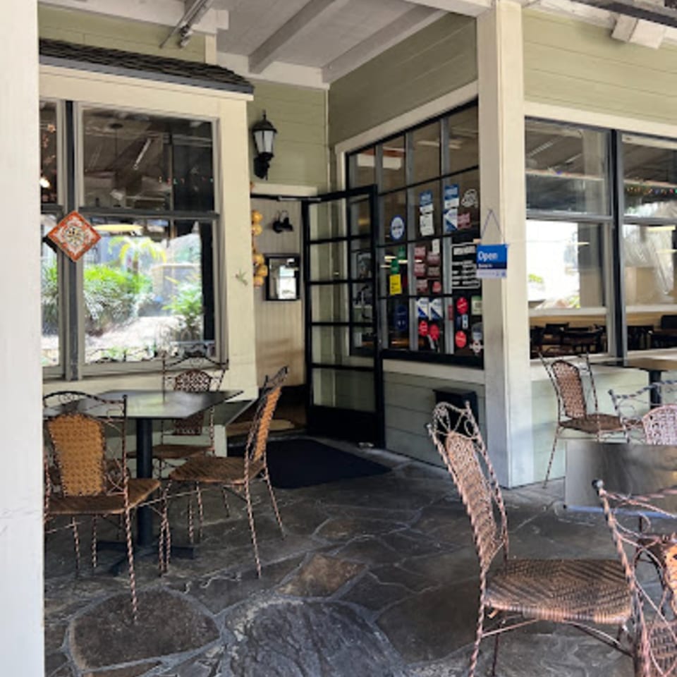 Outdoor patio seating with wrought iron tables and chairs outside Misto Caffe & Bakery.