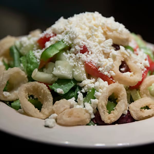 A Misto Caffe & Bakery salad with greens, tomatoes, cucumbers, feta cheese, and fried calamari.