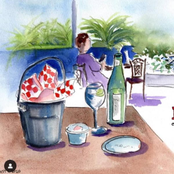Watercolor painting of a person dining outdoors with a bucket of bread, wine, and a drink.